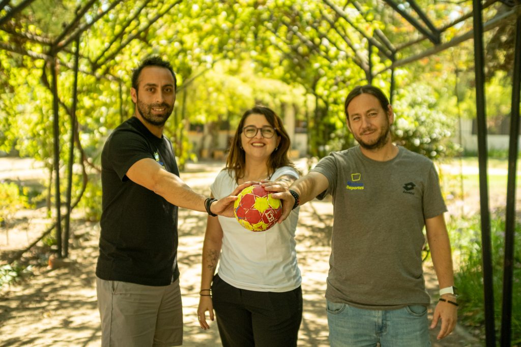 Conductores del podcast Santiago 2023 en 120 segundos. De izquierda a derecha se puede ver a Sebastián Lavín, Carolina Bergeon y Vladimiro Mimica sosteniendo una pelota al centro de la imagen.
